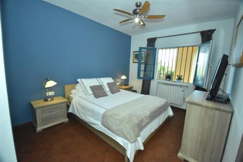 niebieska sypialnia z łóżkiem i telewizorem z płaskim ekranem w obiekcie Cabopino Apartament, Marbella´s Beach w Marbelli