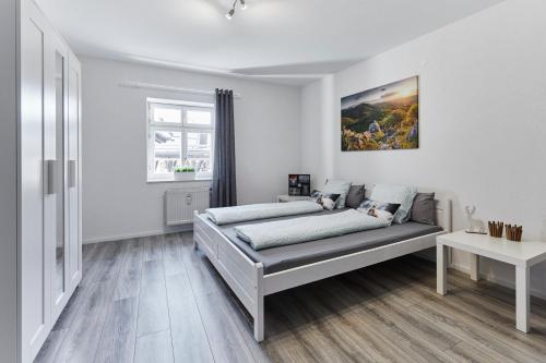 une chambre blanche avec un lit et une fenêtre dans l'établissement Wohnung 5 - nur 5-10 min vom Europapark, à Ettenheim