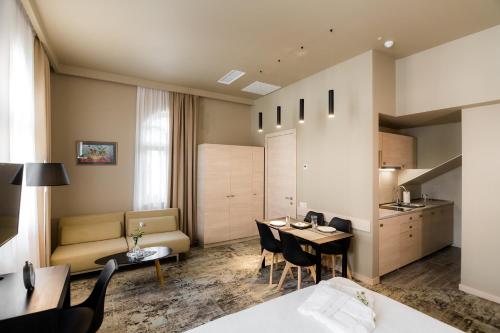 Il comprend un salon avec une table et des chaises ainsi qu'une cuisine. dans l'établissement Boutique Apart Hotel Adagio, à Tbilissi
