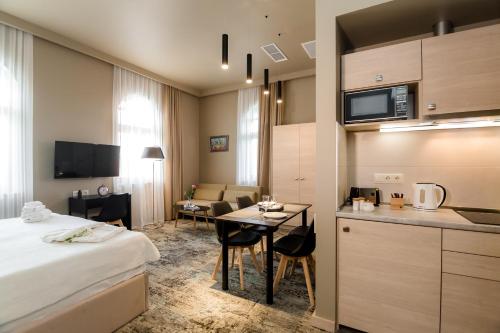 une chambre d'hôtel avec un lit, une table et une cuisine dans l'établissement Boutique Apart Hotel Adagio, à Tbilissi