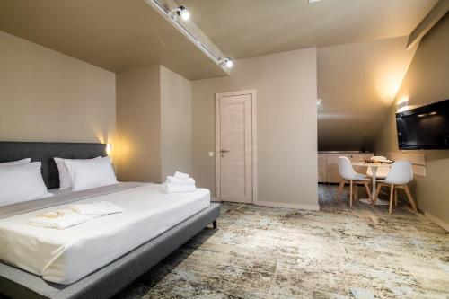 a bedroom with a large bed and a table at Boutique Apart Hotel Adagio in Tbilisi City