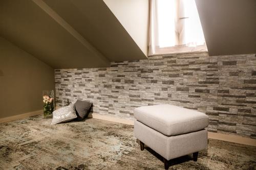 a room with a chair and a brick wall at Boutique Apart Hotel Adagio in Tbilisi City