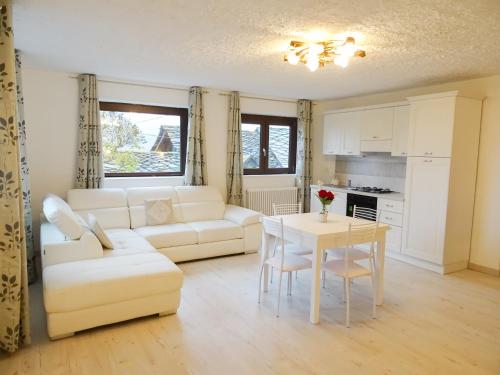 a living room with a white couch and a table at Apartment Chez Nous in Saint-Oyen