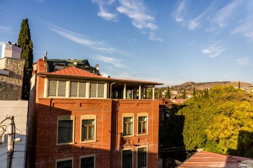 a brick building with a balcony on top of it at Boutique Apart Hotel Adagio in Tbilisi City
