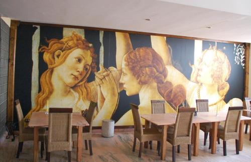 a mural in a restaurant with tables and chairs at Posada Tresmentiras in Aldeanueva del Camino