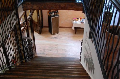 a hallway with a stairs with a refrigerator and a table at Posada Tresmentiras in Aldeanueva del Camino