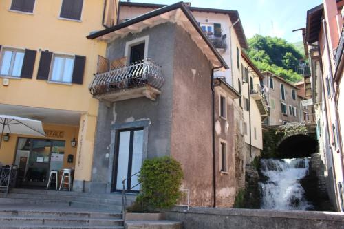 a building with a waterfall in front of a building at Larian Chalet in Moltrasio