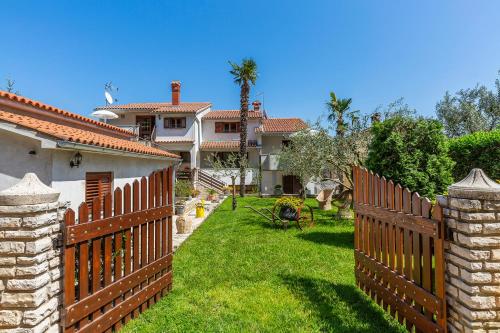a fence in front of a house with a yard at Apartments Rita in Poreč