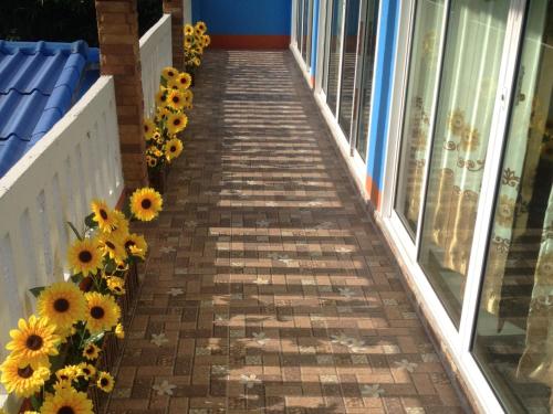 a walkway with sunflowers on the side of a building at Lanta Blue House in Ko Lanta