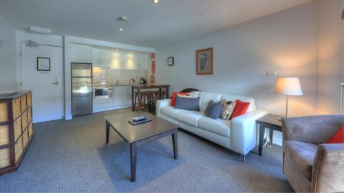 a living room with a couch and a table at Snowgoose Apartments in Thredbo