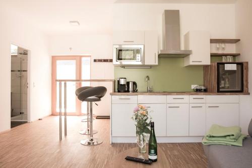 a kitchen with a chair and a bottle of wine at Ferienwohnung am Weingut Eisenbock in Strass