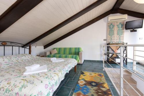 a bedroom with a bed and a green couch at Apartments DDD in Baška