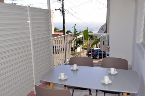 a room with a table and chairs on a balcony at Appartement T4 Schoelcher in Schœlcher