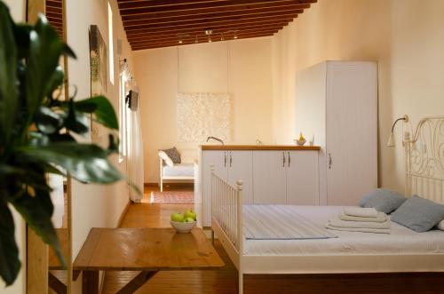 a bedroom with a bed and a table in a room at Dolphin Guest House and Studios in Tochni