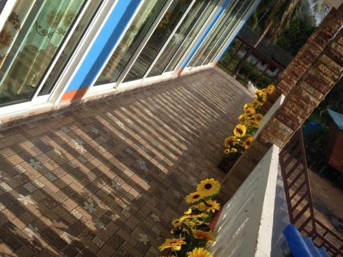 a balcony with a bunch of sunflowers next to a window at Lanta Blue House in Ko Lanta
