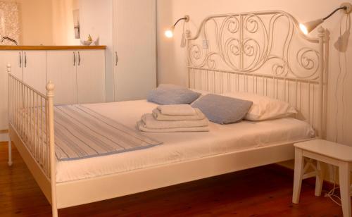 a bedroom with a white bed with towels on it at Dolphin Guest House and Studios in Tochni