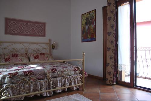 - une chambre avec un lit et une porte donnant sur un balcon dans l'établissement CASA VACANZE "SU PORTALE", à Gonnesa