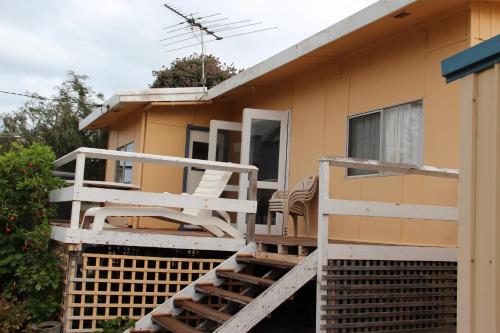 a house with a deck with a chair on it at Brandis Beach House in Guilderton