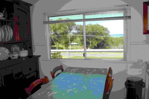 sala de estar con mesa y ventana en Brandis Beach House en Guilderton