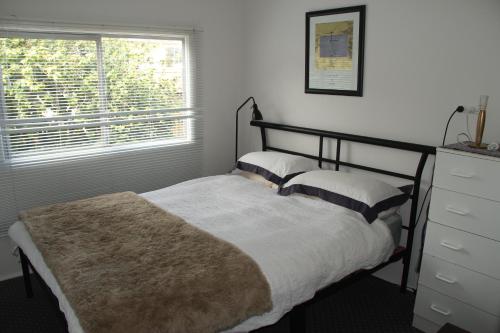 a bedroom with a bed and a window at Brandis Beach House in Guilderton