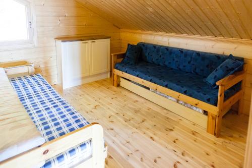 a room with a blue couch and two beds at Kotoranta in Kouvola