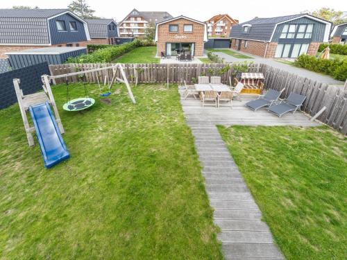 a backyard with a table and chairs and a playground at Haus Leo in Cuxhaven