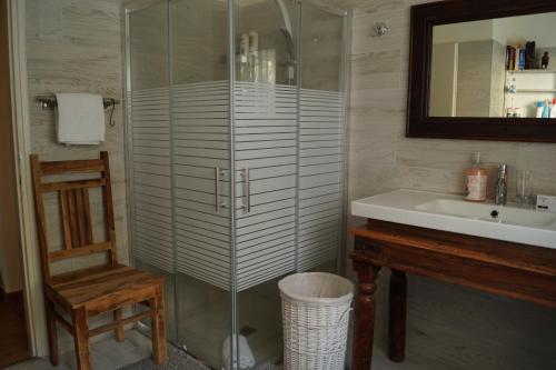 a bathroom with a glass shower and a sink at Goldy Suite in Haifa
