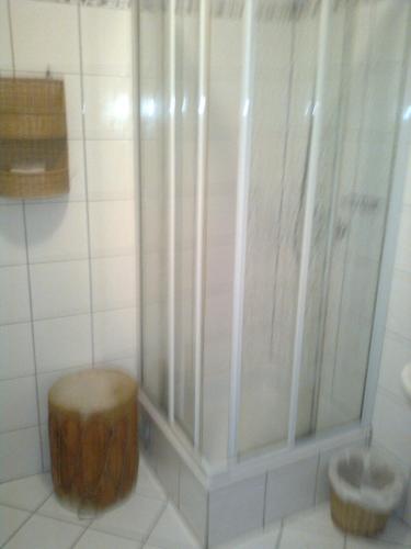 a shower with a wooden stool in a bathroom at Gasthof Weingut Brand Walter in Hörbing