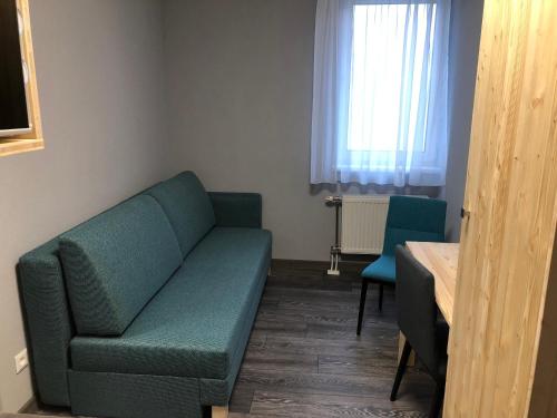 a living room with a green couch and two chairs at Penzión Squash in Liptovský Mikuláš
