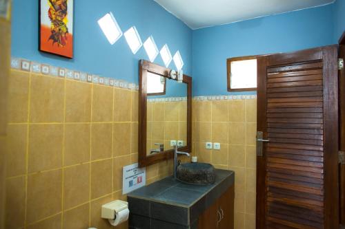 a bathroom with a sink and a mirror at Mandalika Cottage in Gili Trawangan