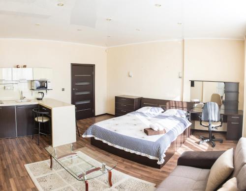 a living room with a bed and a kitchen at Apartment on Kunayeva 38 in Shymkent