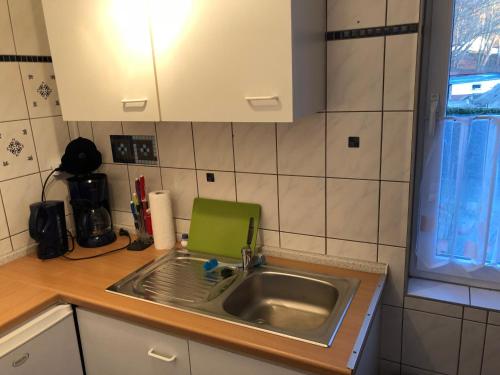 a kitchen sink with a green dish rack next to it at Waldhaus Sellin in Ostseebad Sellin