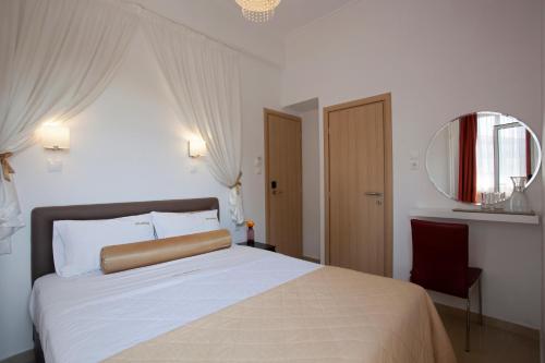 a bedroom with a large bed and a mirror at Metropolis Hotel in Athens
