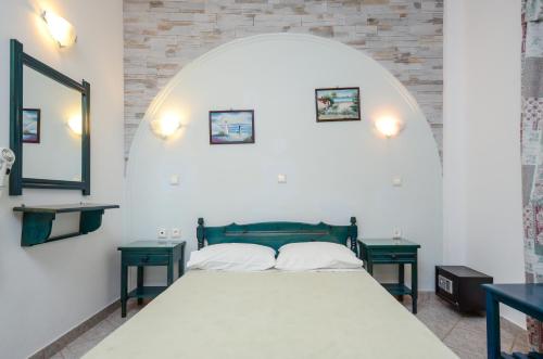 een slaapkamer met een bed met twee groene tafels bij Polemis Studios & Apartments in Agia Anna Naxos