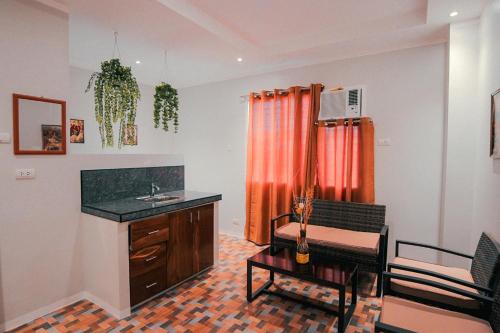 a bathroom with a sink and a desk and a table at Kingswick Residences & Lodge in Dumaguete