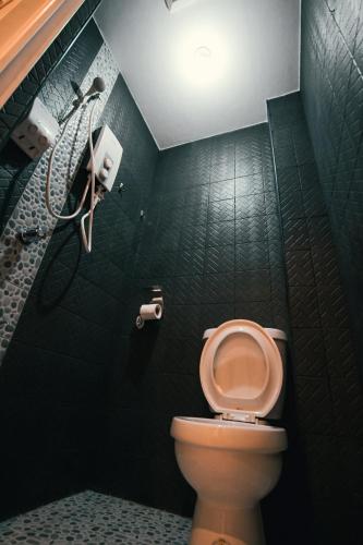 a bathroom with a toilet and a shower at Kingswick Residences & Lodge in Dumaguete