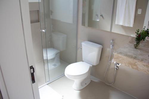 
a white toilet sitting next to a bathroom sink at Tri Pousada Caracol in Canela
