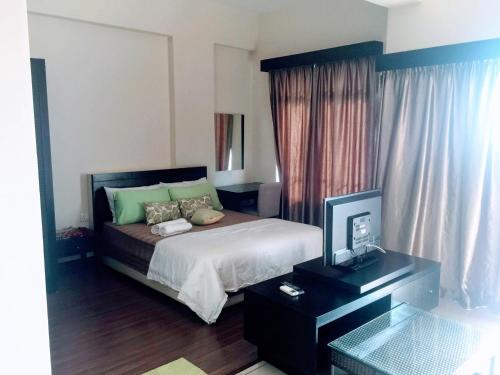 una camera con letto e scrivania con TV di Amari Lagoon Park Resort a Malacca