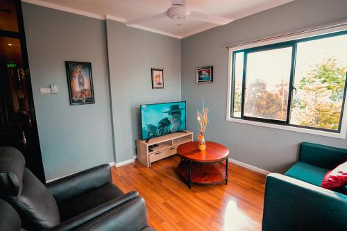 a living room with a couch and a television at Kingswick Residences & Lodge in Dumaguete