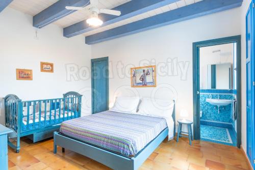 een blauwe en witte slaapkamer met een bed en een spiegel bij Casa Azzurra - Road to Sicily in Marina di Ragusa