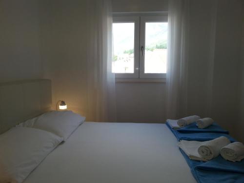 a bedroom with a bed with towels and a window at Apartments Grozdana in Gradac
