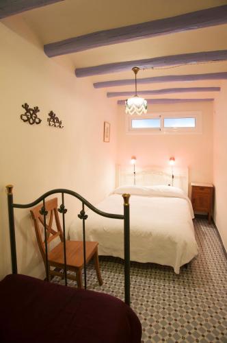 a bedroom with a bed and a chair and a window at El 3 del Holandés in Balaguer