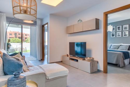 a living room with a bed and a tv at Surfer's Beach Apartment in La Tejita