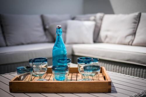 a tray with a bottle and glasses on a table at Surfer's Beach Apartment in La Tejita
