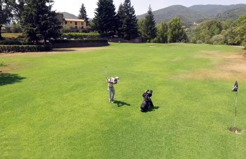 a man and a dog playing golf on a field at Cà Del Moro Resort & SPA in Pontremoli