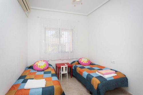 シウダー・ケサダにあるCH Villa Isla Menorca Ciudad Quesadaのベッド2台とテーブルが備わる客室です。