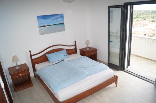 um quarto com uma cama com duas mesas de cabeceira e uma janela em Villa Cavour - Doppelhaushälfte em Budoni