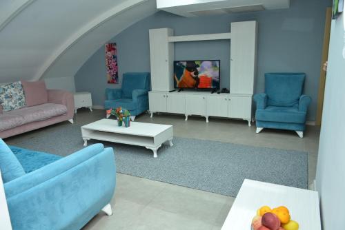 a living room with blue chairs and a tv at Nar Palace in Istanbul