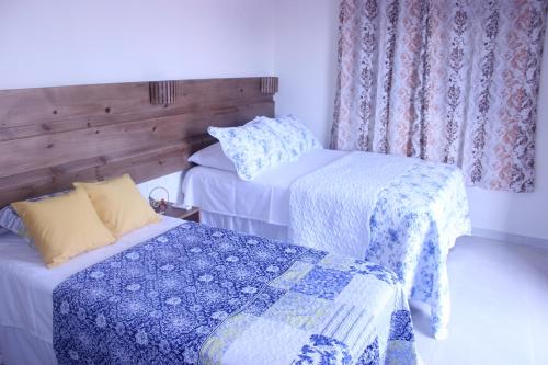 a room with two beds with blue and white sheets at Flats Lírios do Mar in São Miguel do Gostoso