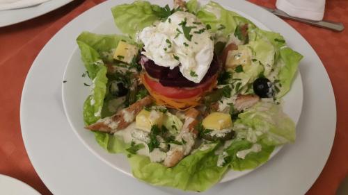 a white plate with a salad on a table at Numidien Hotel in Alger